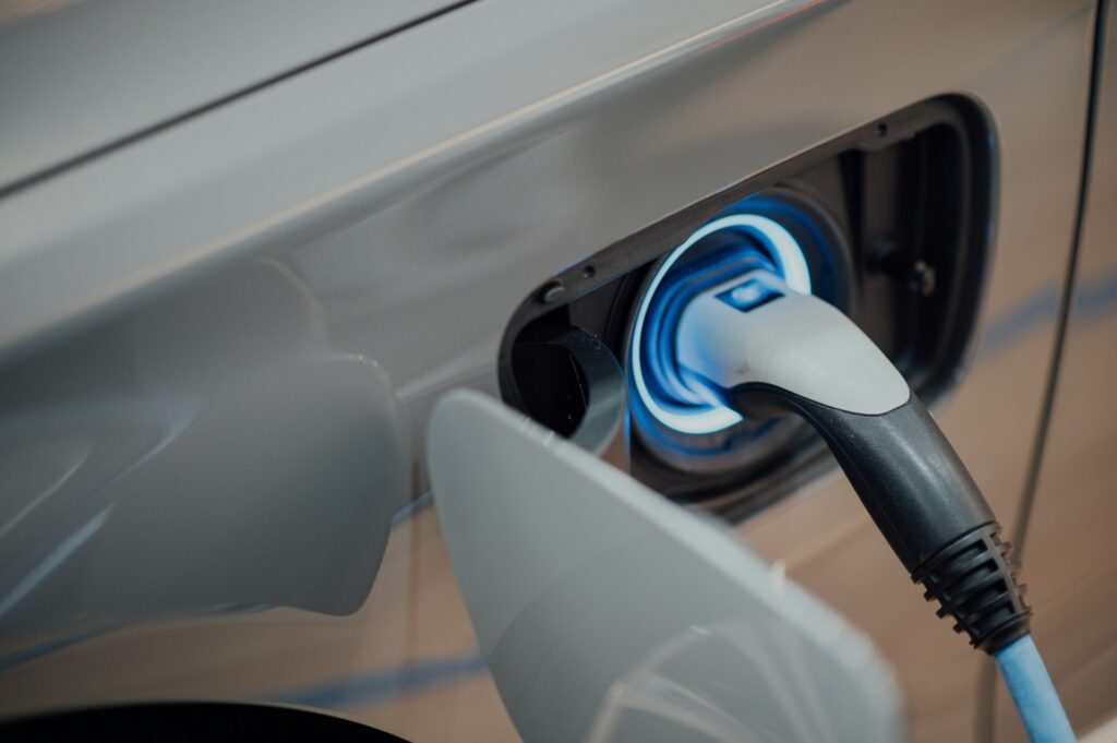 Close-up of an EV charging port and cable, highlighting the best electric cars for teens.