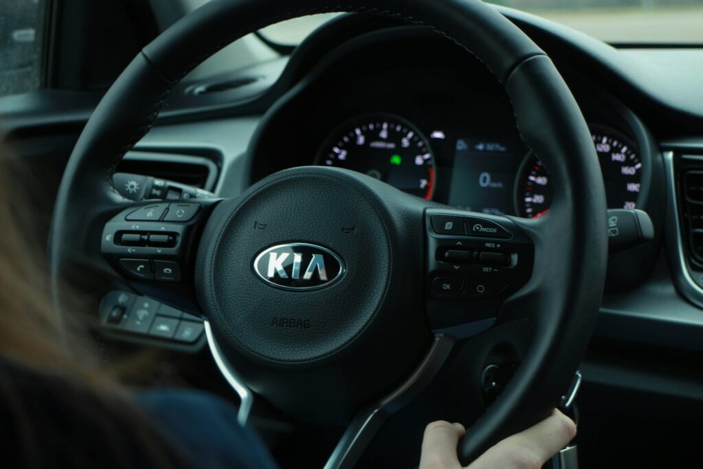 A close-up of a Kia steering wheel interior, symbolizing the driving experience featured in the kia niro ev vs tesla model y conversation.