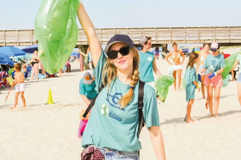 earthday global and US based cleanups girl holding green bin bag
