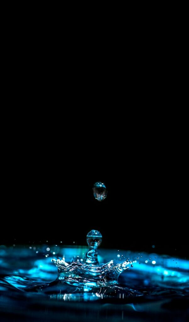 Water droplet splashing into a pool of blue liquid, symbolizing the purity and precision of a Japanese water purifier.