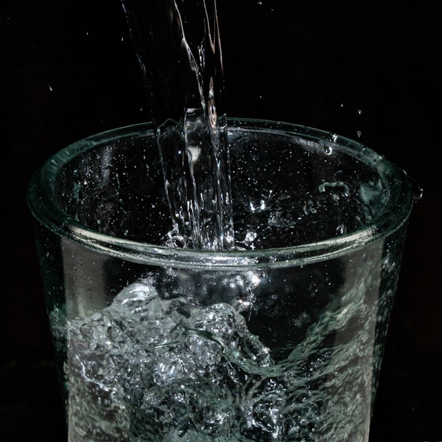 Fresh water being poured into a glass, symbolizing clean hydration from a Japanese water purifier.