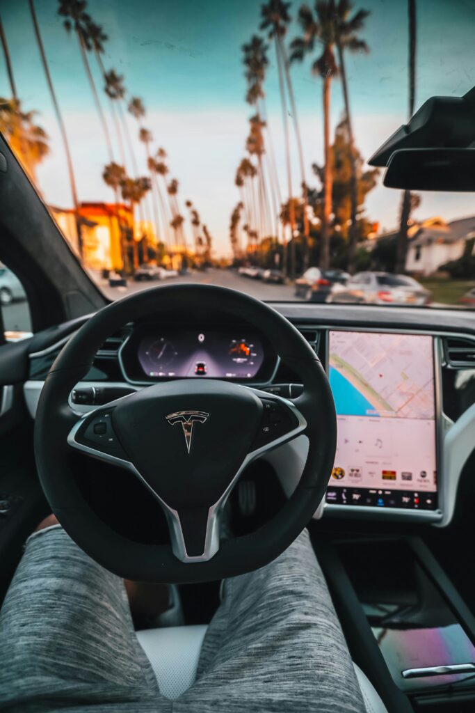 Tesla Glove Box with steering wheel and mans legs in view