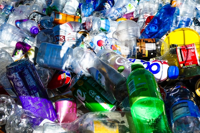 A colorful pile of plastic bottles and cans ready for sorting, highlighting the need for better waste management and increased EPS recycling awareness.