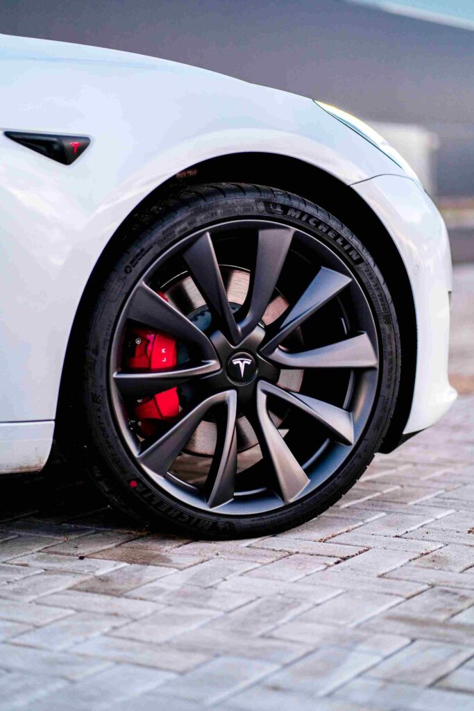 Close-up of a Tesla wheel and tire on a paved surface, showcasing premium performance for the best tires for Tesla.