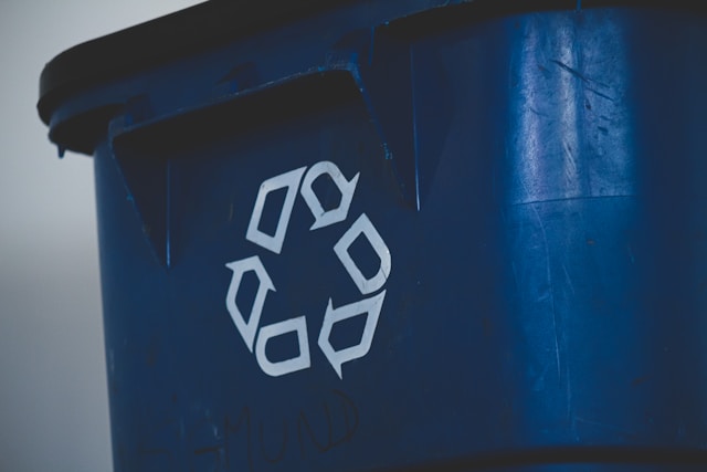 Close-up of a blue container with a recycling symbol, representing a designated battery recycle bin for safe and eco-friendly disposal.
