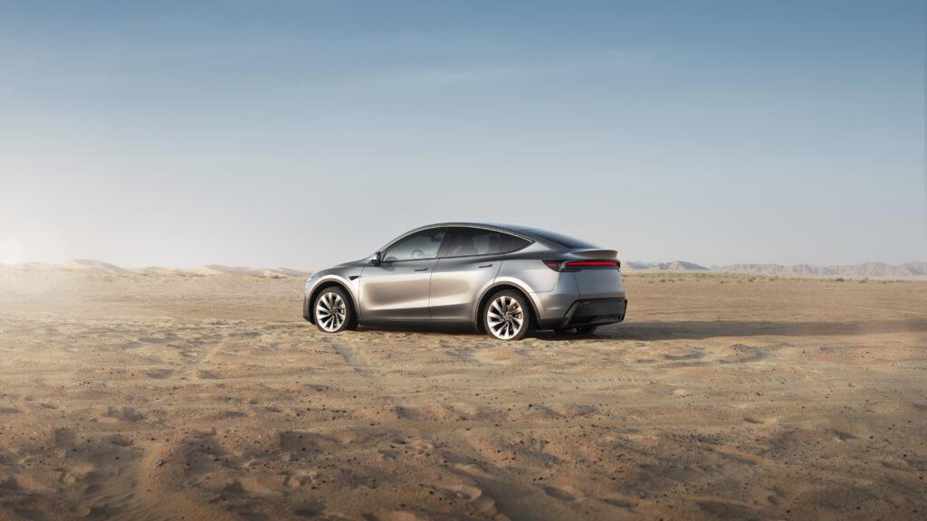 A silver Tesla Model Y parked in an open desert landscape under the intense sun, highlighting the importance of using the best sunshade for Tesla Model Y to protect the interior from extreme heat.