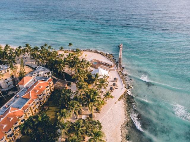 Aerial view of a tropical beach resort with palm trees and turquoise waters on the Caribbean coast, illustrating ecotourism Puerto Rico.