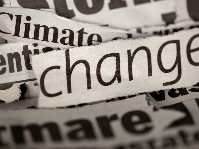 Close-up of newspaper headlines with the word ‘change’ highlighted, symbolizing public attention and media coverage of climate change lawsuits and environmental accountability.