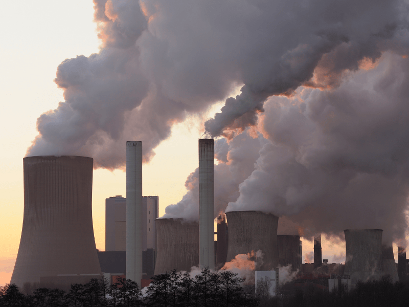 Coal power plant emitting thick smoke and air pollution, highlighting the environmental impact of dirty energy in the United States.