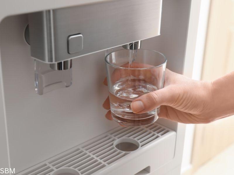 Close-up of a hand filling a glass with water from a modern water purifier machine for business use, emphasizing clean and accessible drinking water in a professional setting.









Ask ChatGPT
