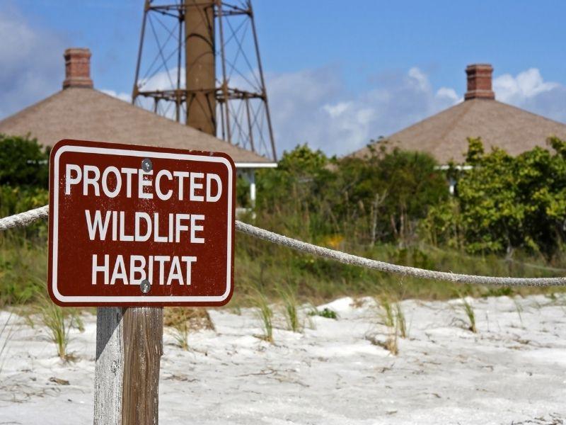 Protected wildlife habitat sign on a sandy beach in Florida, emphasizing conservation and the importance of ecotourism Florida Keys.