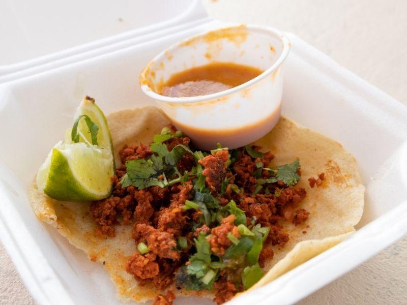 Mexican taco with lime and salsa served in a white Styrofoam container, raising health concerns about is styrofoam toxic or safe for food use.