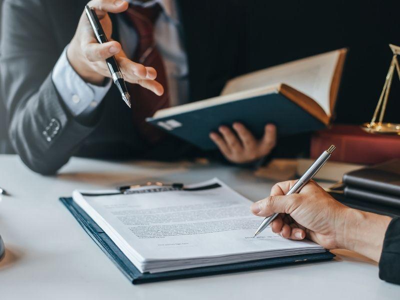 Lawyers reviewing documents and contracts related to the NW Natural climate change lawsuit, symbolizing legal action on fossil fuel accountability and environmental responsibility.