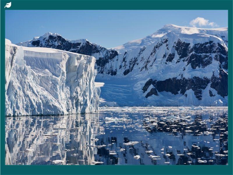 Towering glaciers and rugged snow-covered peaks reflecting in icy waters of Antarctica: the world’s largest desert.
