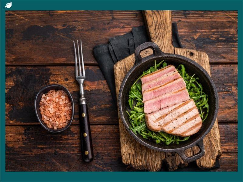 Grilled Yellowfin tuna steak served on fresh greens representing Yellowfin tuna sustainability and importance for oceans, food security, and eco-friendly fishing.