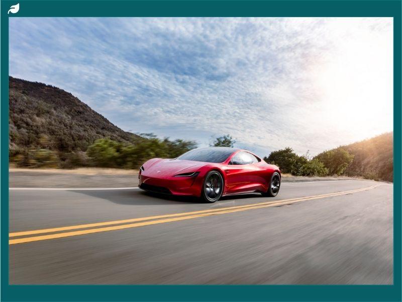 Red Tesla sports car driving on an open highway under a bright sky, representing Tesla delivery estimates 2025 and the future of electric vehicle performance.