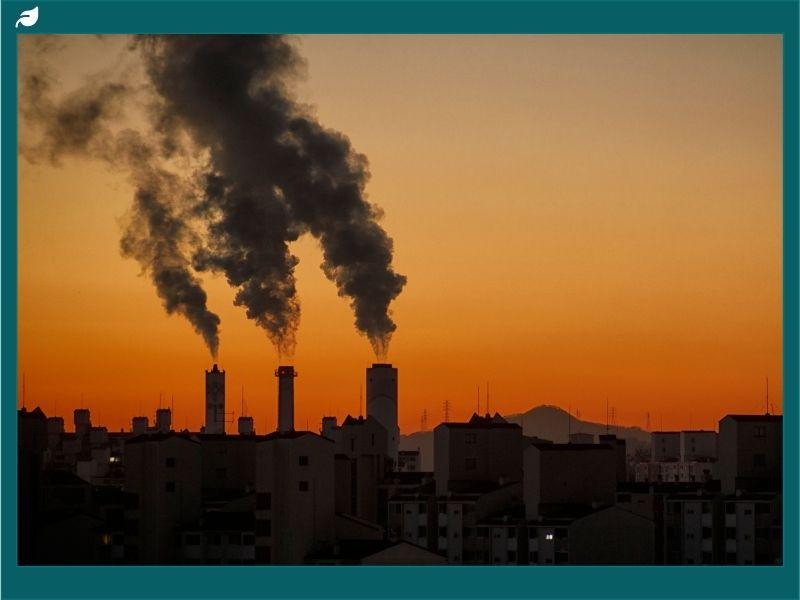 Smoke billowing from chimneys of a coal power plant at sunset, illustrating the Trump administration coal policy and its environmental and emissions implications."