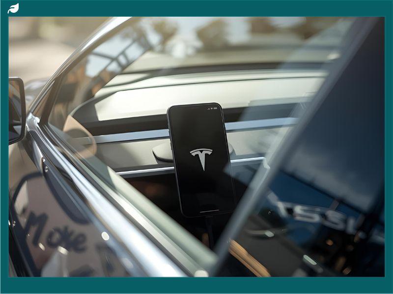Tesla Pi Phone 2026 concept inside a Tesla vehicle, showing a smartphone with the Tesla logo integrated into the dashboard — symbolizing advanced connectivity between Tesla cars and the upcoming Tesla phone.