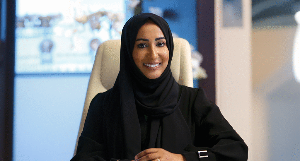 H.E. Dr. Shaikha Salem Al Dhaheri, Secretary General of the Environment Agency – Abu Dhabi, seated in her office, smiling confidently while wearing a black abaya and hijab