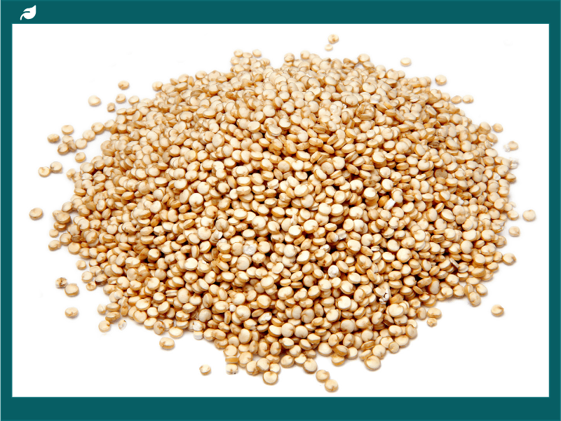 Quinoa vs rice comparison showing uncooked white rice in a wooden bowl.