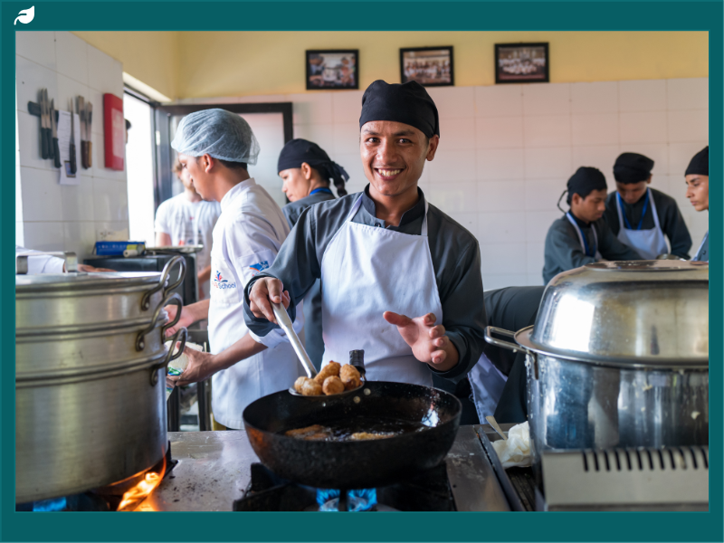 Young hospitality trainees cooking in a FAB school kitchen in Nepal, showcasing a sustainable development initiative focused on vocational education.