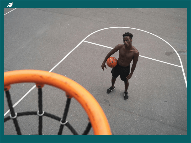 Man playing basketball on outdoor court.