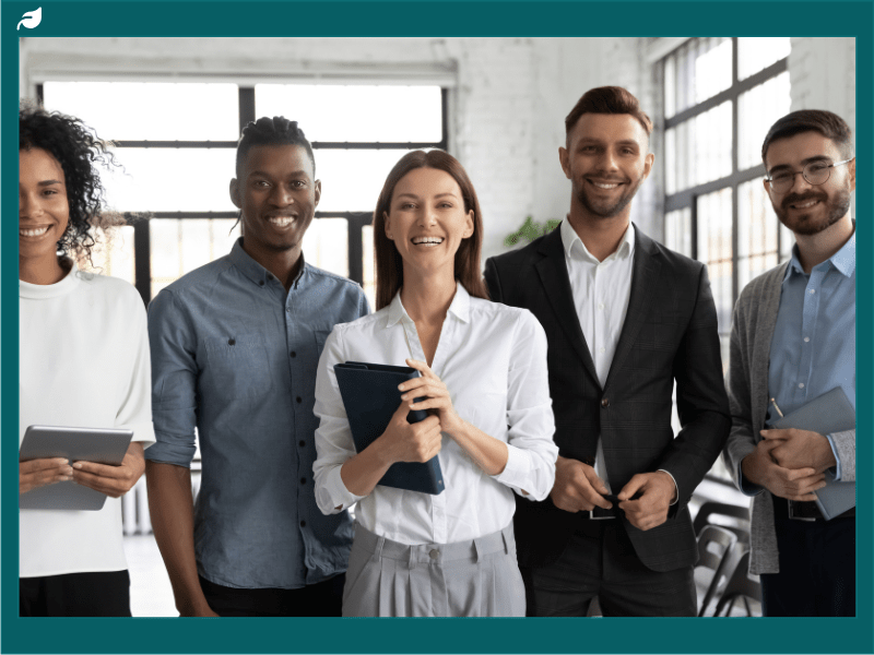 Corporate portrait successful smiling diverse employees team standing in office