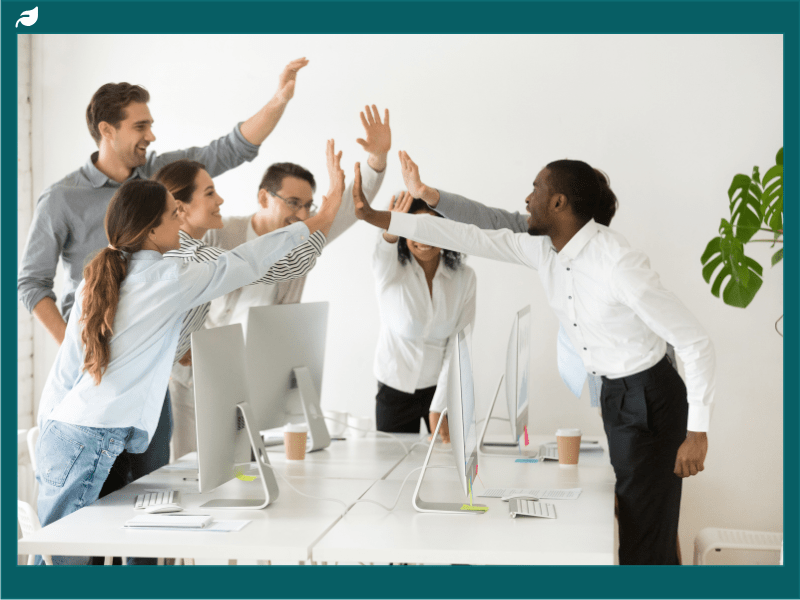 Diverse work team giving high five celebrating shared corporate success