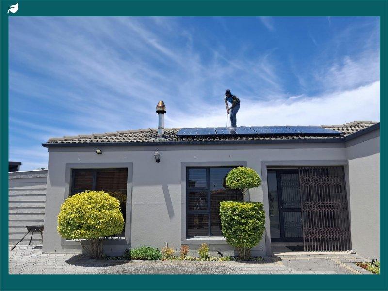 Worker Installing Solar Panels on Residential Roof