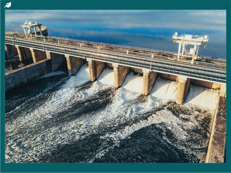 Hydroelectric dam or hydro power station at water reservoir, aerial view from drone. Draining water through gate, hydropower