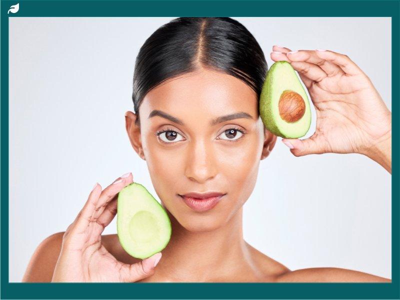 Portrait, Avocado and Woman with Natural Beauty, Facial and Eco Friendly Skincare Isolated on White Background. Wellness, Dermatology and Vegan Cosmetics Product with Glow, Shine and Green in Studio