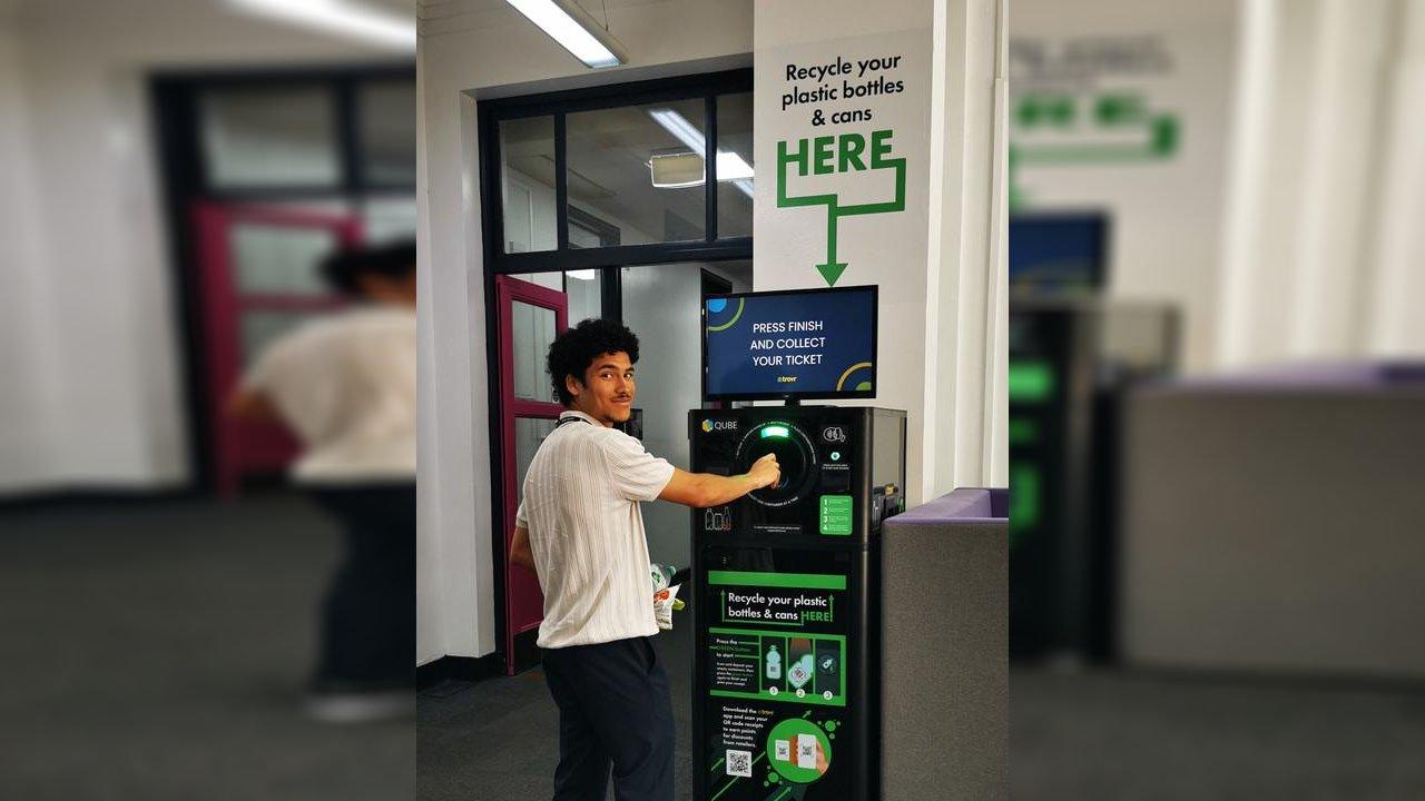 Student depositing a plastic bottle into the TrovrQUBE recycling unit at Reading College and University Centre