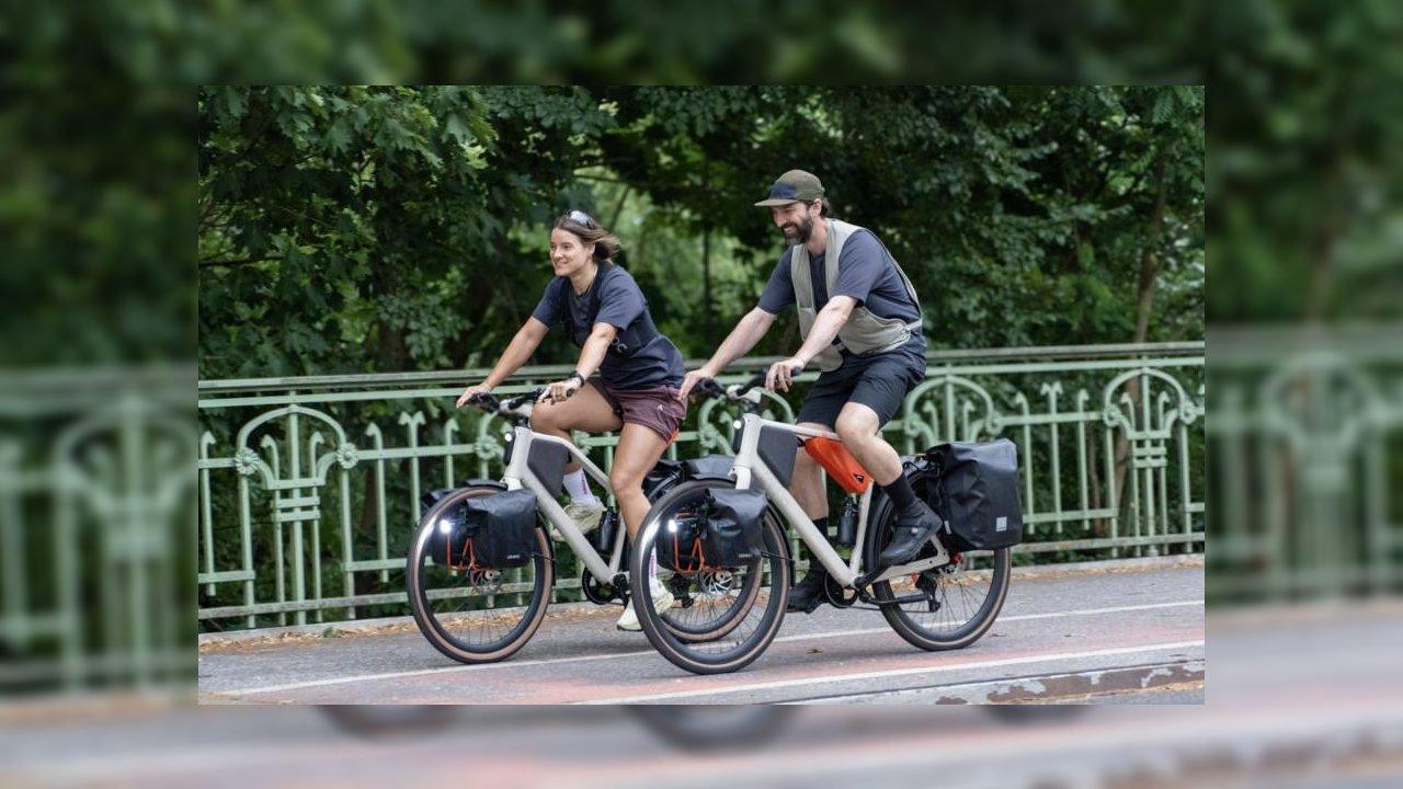 Man and woman riding Lemmo One ebikes side by side on a paved path