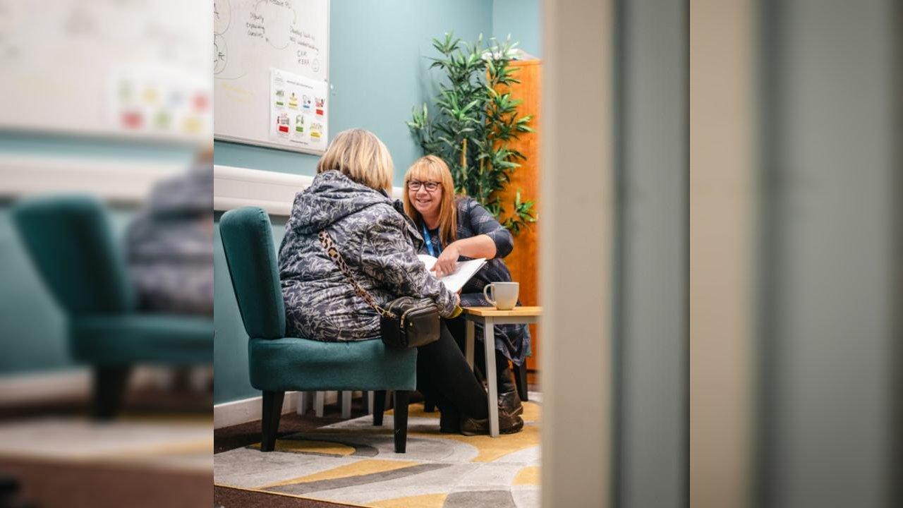 Two women reviewing a fuel poverty policy document in an office setting