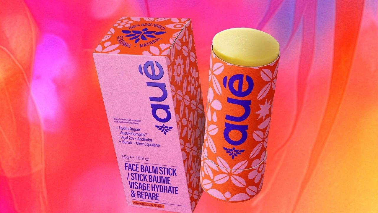 A face balm stick and its packaging box are displayed against a vibrant, multi-colored background.
