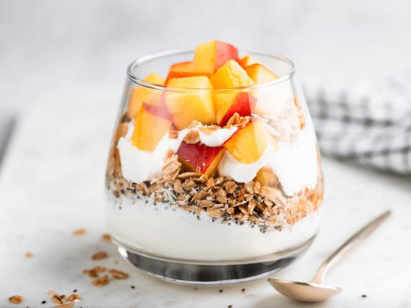 A Greek yogurt parfait layered with granola and peach