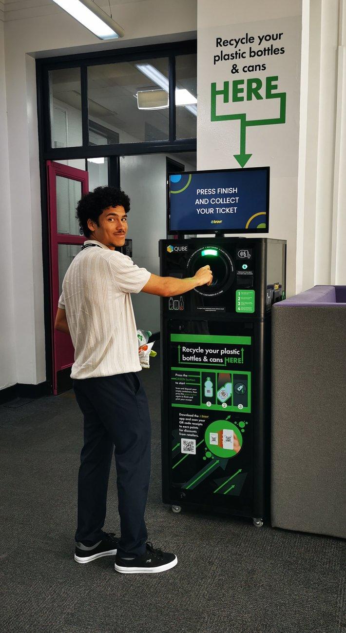 Student depositing a plastic bottle into the TrovrQUBE recycling unit at Reading College and University Centre