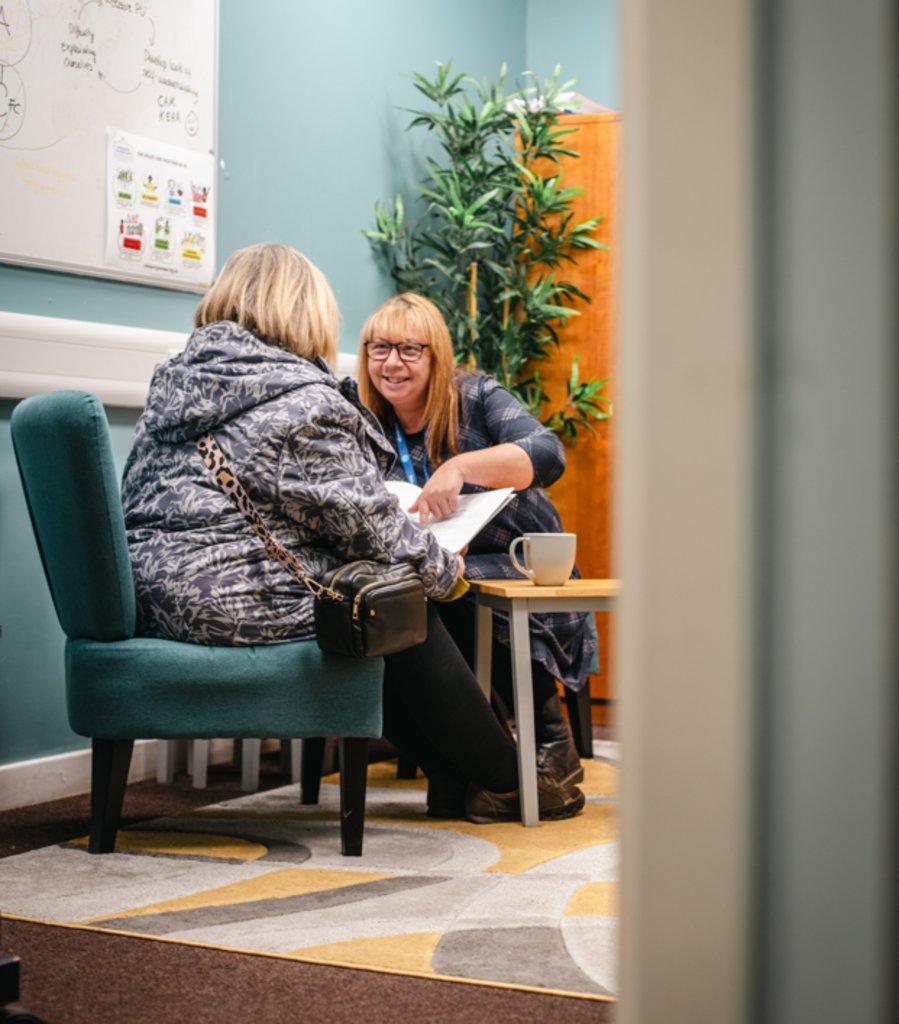 Two women reviewing a fuel poverty policy document in an office setting