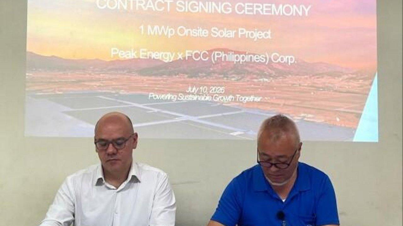Sandro Bruni of Peak Energy and Tsuyoshi Nakada of FCC Philippines signing the solar power agreement at a ceremony.