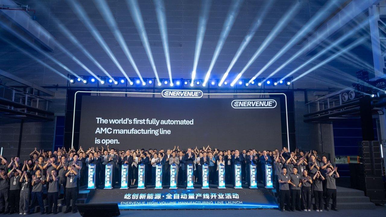 Employees onstage at EnerVenue’s high-volume manufacturing line launch beneath blue spotlights.