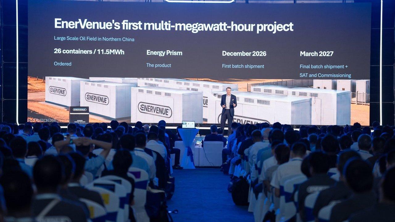 A speaker presents an EnerVenue energy storage project slide to an audience.