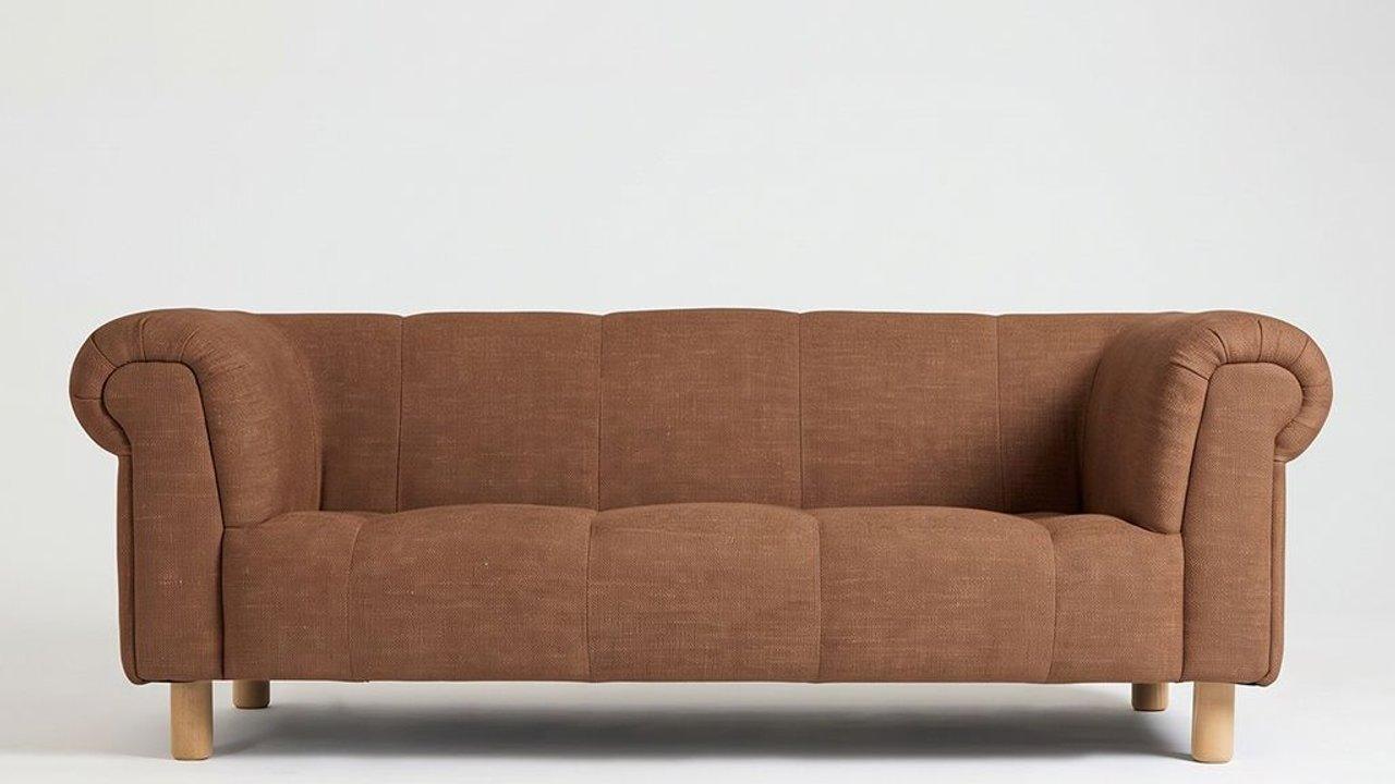 Brown upholstered three-seat sofa with rolled arms and wooden legs against a plain white background.
