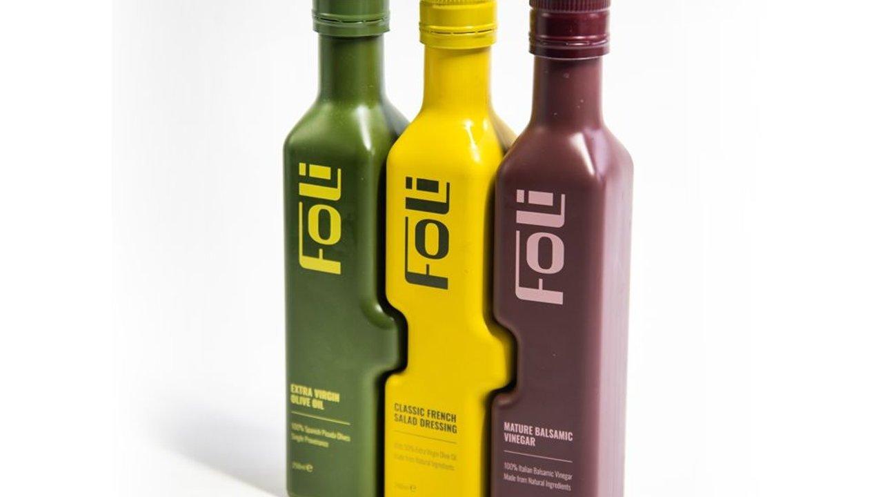 Three bottles of olive oil, French salad dressing and balsamic vinegar.