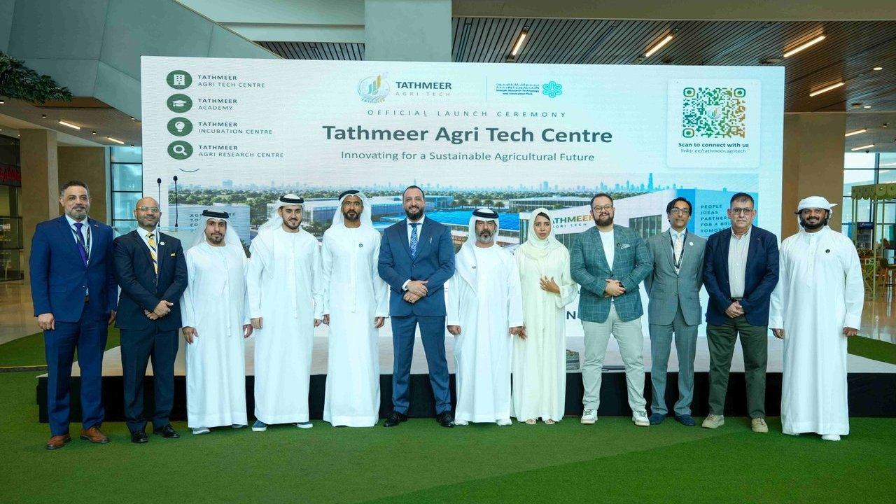 Group of attendees standing before a Tathmeer Agri Tech Centre launch ceremony sign.