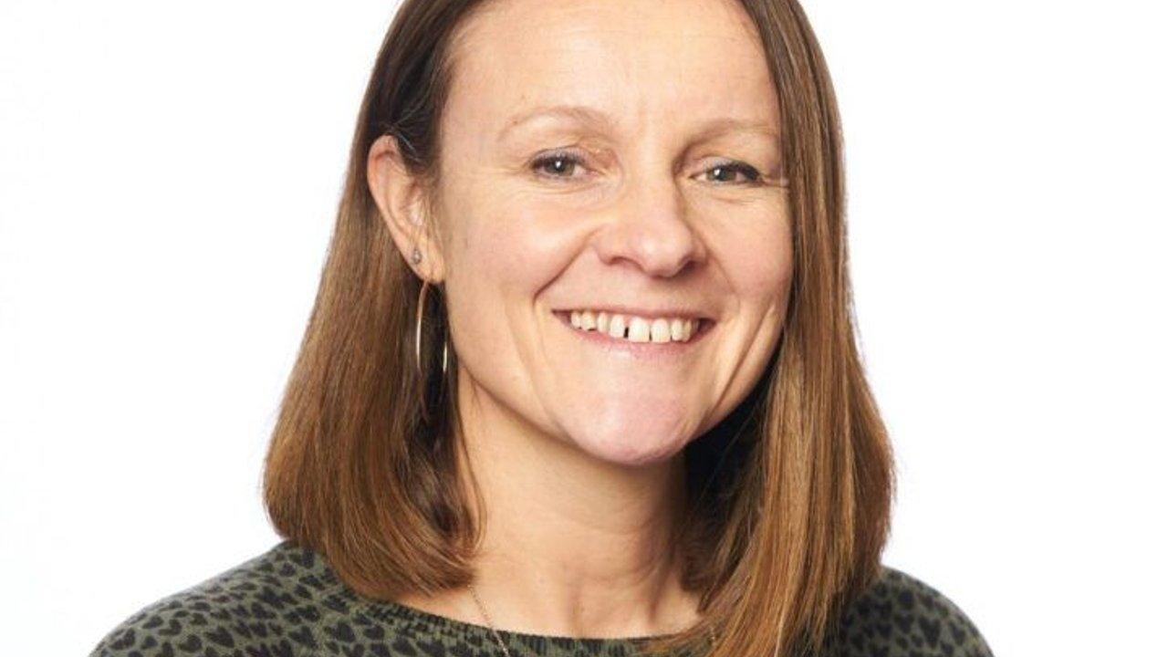 Karen Higgins smiling against a white background.