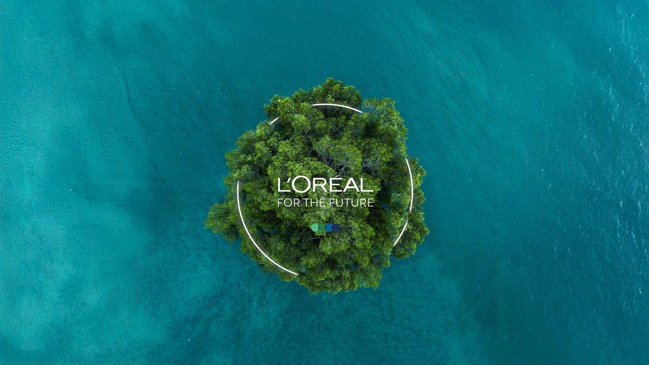 A tree-covered island in turquoise water with the L’Oréal for the Future logo.