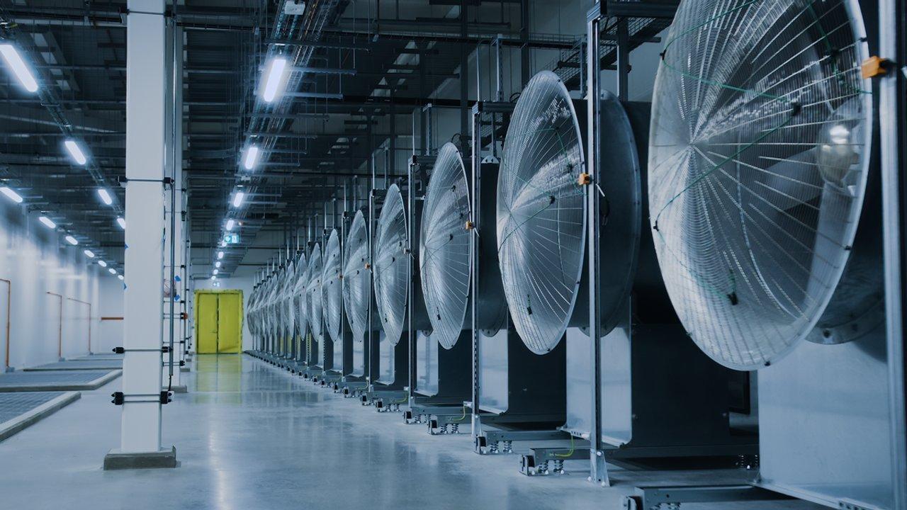 Rows of large industrial cooling fans inside a data centre facility.