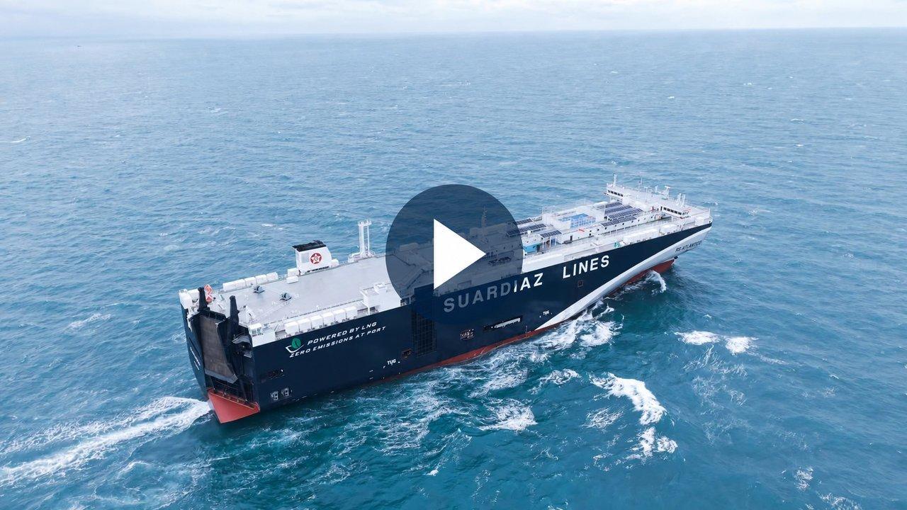 A cargo ship sailing through the ocean, with a video play button overlay.