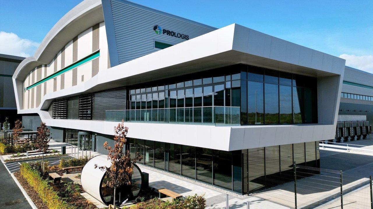 Modern Prologis warehouse and office building with glass windows, loading docks and landscaped grounds.