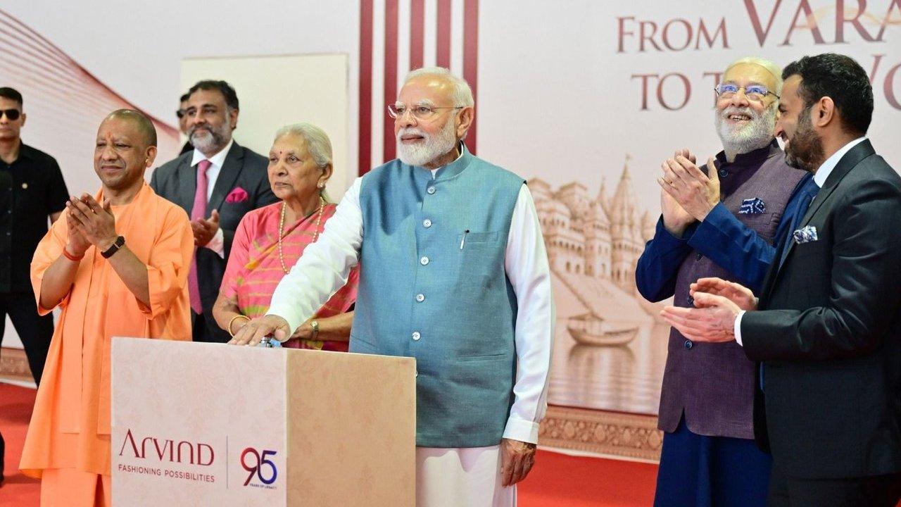 Narendra Modi presses a button beside Yogi Adityanath and other attendees at an Arvind event.
